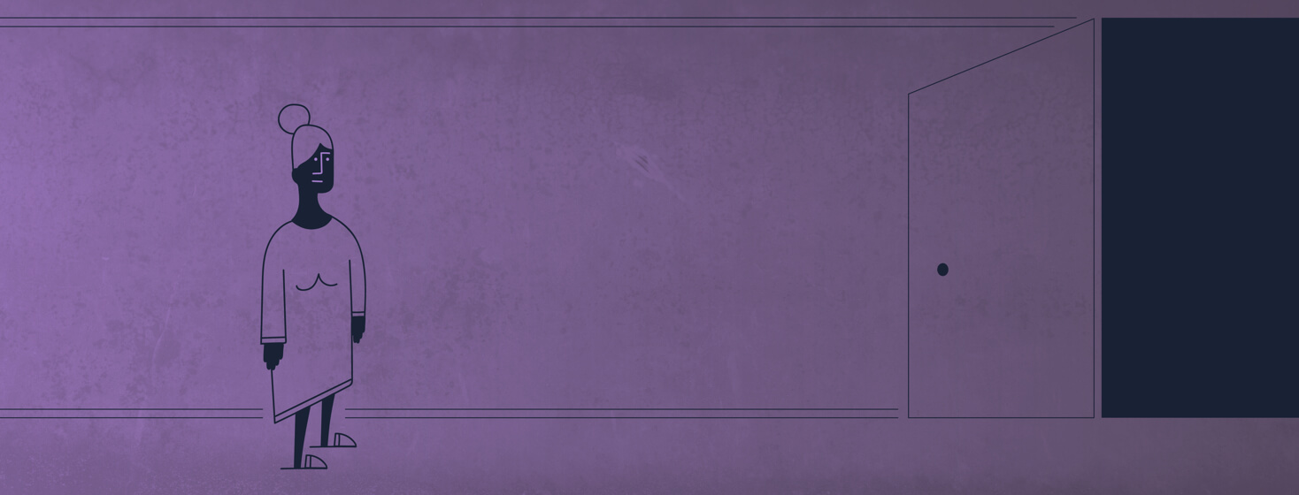 a woman standing at the end of a hallway in a nightgown and slippers looking towards her dark bedroom