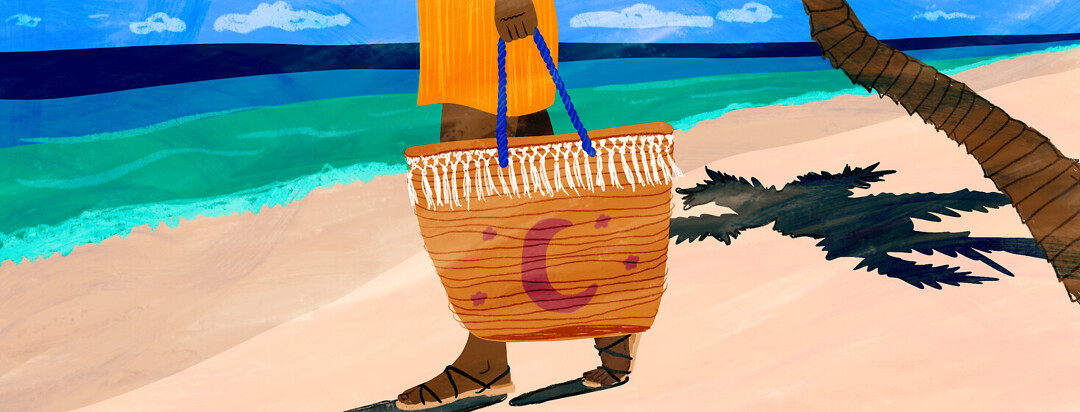 A woman walks down the beach holding a beach bag with a moon and stars on it