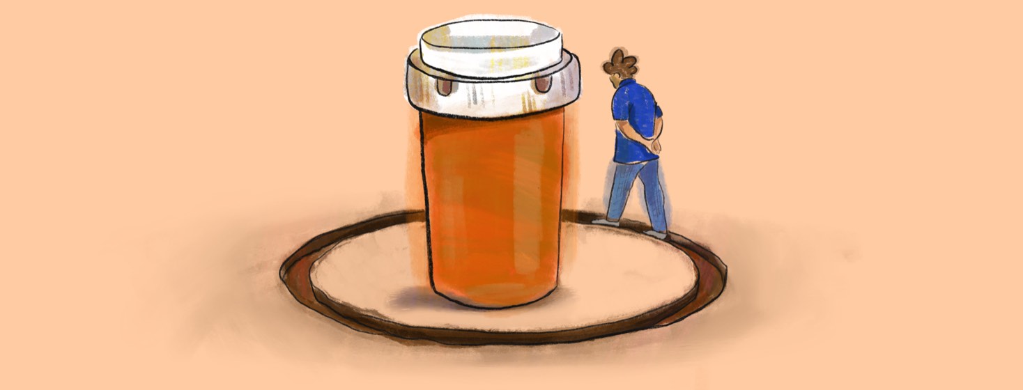 A person carving a circular rut in the ground around a giant pill bottle from circling around it so many times.