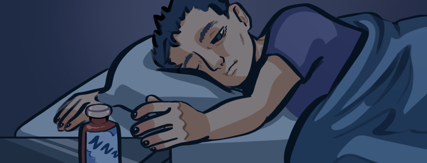 A sleepy man in bed reaching toward a bottle of melatonin sitting on his bedside table.